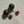 Load image into Gallery viewer, Pair of earrings with red and black spherical stones on a textured beige surface

