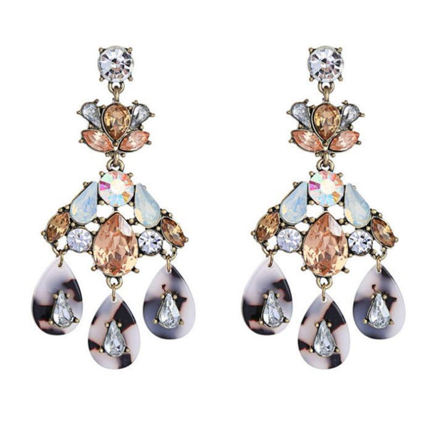 Pair of ornate earrings with gemstones on a white background