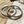 Load image into Gallery viewer, Two silver bangles on a stone surface with sand and driftwood in the background
