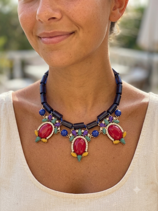 Close-up of a person wearing a colorful beaded necklace with red stones.