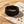 Load image into Gallery viewer, Black braided bracelet on a textured surface with sand and pebbles
