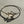 Load image into Gallery viewer, Silver bracelet with a decorative clasp on a textured beige surface

