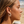 Load image into Gallery viewer, Woman wearing star-shaped earrings on a beach
