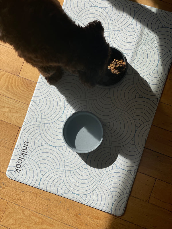 Cat pawing at a catnip toy on a patterned mat with 'unkitlook' branding.