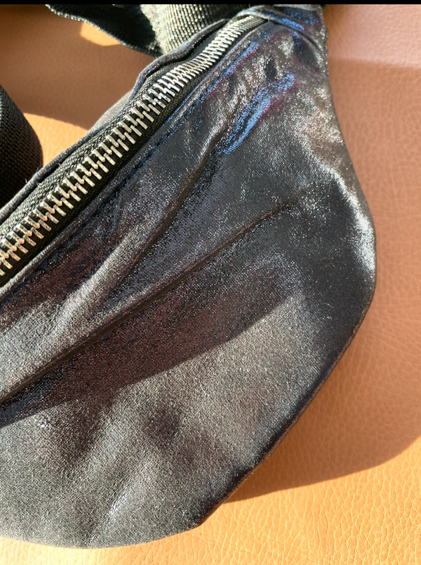 Silver fanny pack on a beige surface
