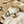 Load image into Gallery viewer, Gold earrings on a marble surface with sand and stones in the background
