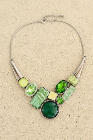 Necklace with green and silver design on a dark surface