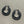 Load image into Gallery viewer, Pair of black hoop earrings on a beige textured surface
