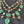 Load image into Gallery viewer, Necklace with green gemstones on a dark textured background
