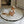 Load image into Gallery viewer, A baby sitting on a round, quilted, black and cream colored padded floor mat with a pillow.
