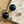 Load image into Gallery viewer, Black spherical earrings with gold posts on a marble surface with sand and small stones.

