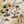 Load image into Gallery viewer, Silver infinity symbol earrings on a stone surface with seashells and sand.
