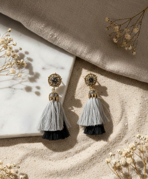 Tassel earrings on a textured surface with dried flowers