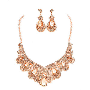 Rose gold necklace and earrings set on a white background