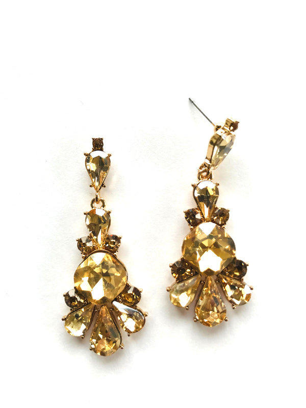 Pair of gold and amber crystal earrings on a white background