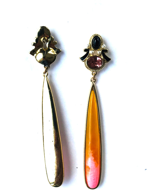 Pair of earrings with gold and pink teardrop shapes on a white background