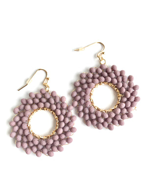 Pair of pink beaded earrings with gold loops on a white background