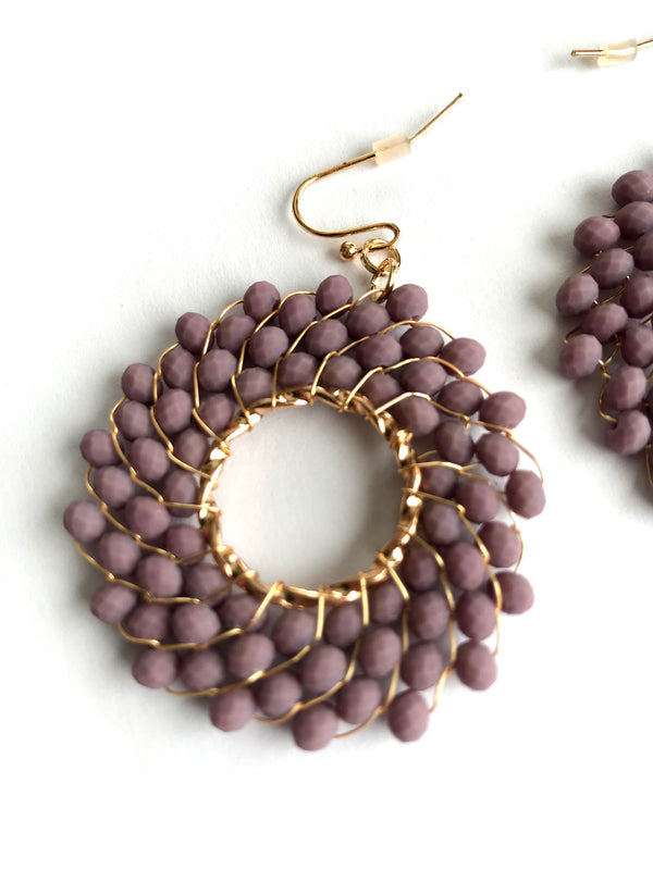Earrings with purple bead design on a white background