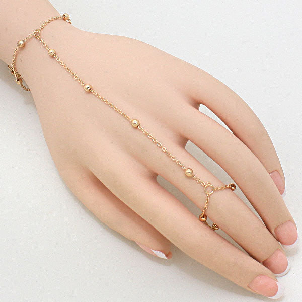 Gold bracelet and ring set on a hand against a white background