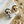Load image into Gallery viewer, Pair of gold and silver spherical earrings on a textured surface with shells.
