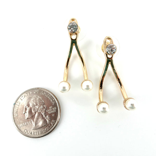 Gold earrings with pearl-like beads next to a quarter on a white background