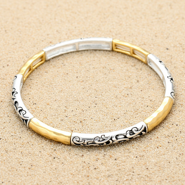 Two-tone silver and gold bracelet with black floral patterns on a white background