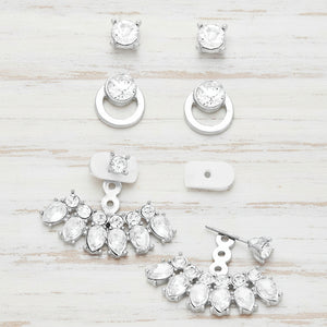 Set of silver earrings with clear gemstones on a white background
