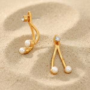 Gold earrings with pearl-like beads on a white background