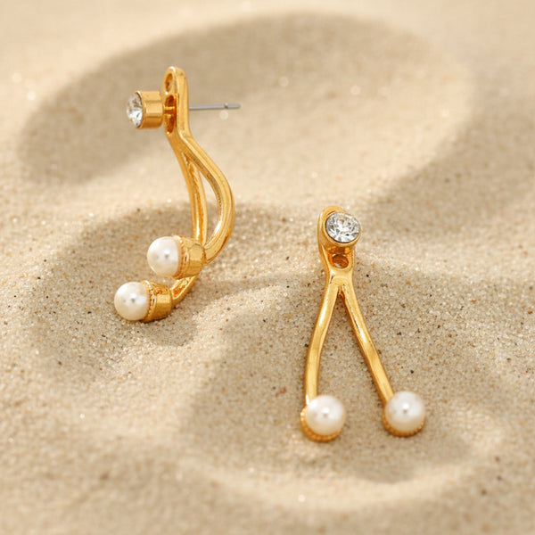 Gold earrings with pearl-like beads on a white background