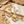 Load image into Gallery viewer, Gold earrings with clear stones on a sandy surface
