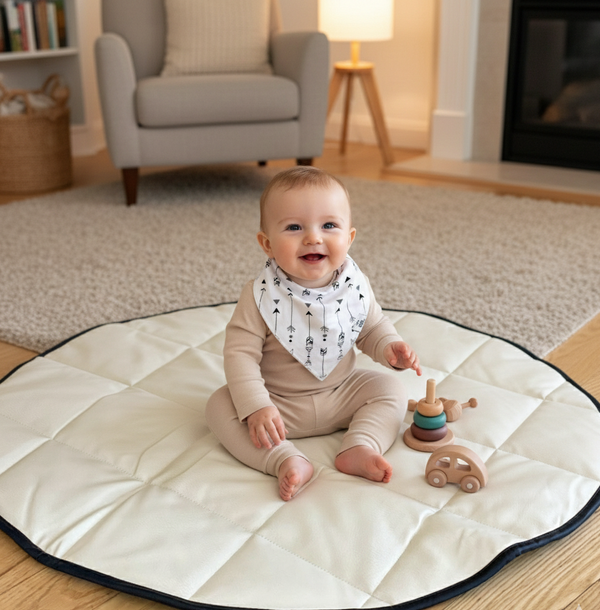 Baby sitting on a round play mat in a living room with toys around