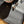 Load image into Gallery viewer, A black and cream vegan leather pet food mat with the brand name 'uniklook' embossed on it, featuring a bowl of cat food on top and a few scattered kibbles around.
