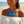 Load image into Gallery viewer, A woman on a beach wearing a chunky blue disc necklace with silver beaded accents and matching blue drop earrings, paired with a white off-the-shoulder top.
