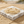 Load image into Gallery viewer, Gold bracelet on a marble stone with sand in the background
