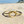 Load image into Gallery viewer, Gold bracelet with interlocking rings on a sandy beach

