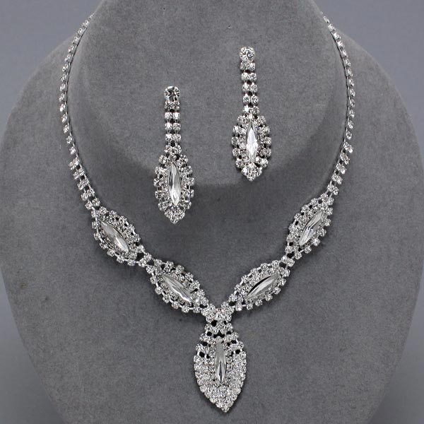 Clear rhinestone necklace and matching earrings on gray jewelry display