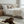 Load image into Gallery viewer, Dog lying on a mat in a bedroom with a bed and pillows in the background
