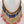 Load image into Gallery viewer, Necklace and earrings set with red, blue, and gold beads on a mannequin.
