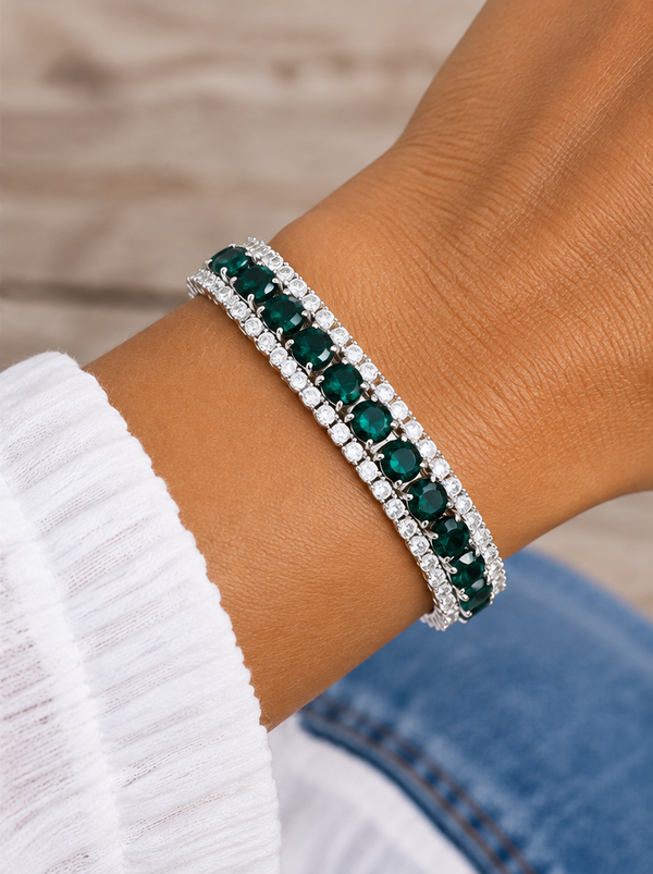 Emerald green crystal tennis bracelet worn on a tanned wrist