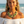 Load image into Gallery viewer, A woman on a beach wearing a green beaded multi-strand necklace and matching drop earrings, with ocean waves blurred in the background.
