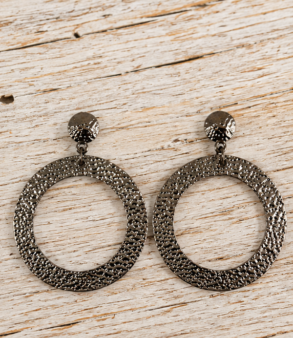 Hammered gunmetal circle earrings on pale barn wood