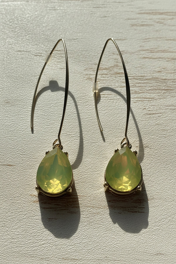 Teardrop-shaped green earrings on a light gray background