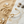 Load image into Gallery viewer, Gold bracelet on a marble surface with sand and stones in the background
