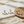 Load image into Gallery viewer, Gold and pearl earrings on a marble surface with a woven mat.
