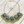 Load image into Gallery viewer, Necklace with green and gold beads on a wooden surface
