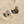 Load image into Gallery viewer, Two gold and crystal earrings on a sandy surface
