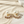 Load image into Gallery viewer, Pearl earrings with small purple stones on a sandy surface
