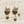 Load image into Gallery viewer, Pair of pearl earrings on a textured stone surface
