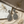 Load image into Gallery viewer, Pair of silver earrings on a textured surface with dried flowers.
