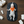 Load image into Gallery viewer, Baby lying on a dark mat with diaper changing supplies on a wooden surface
